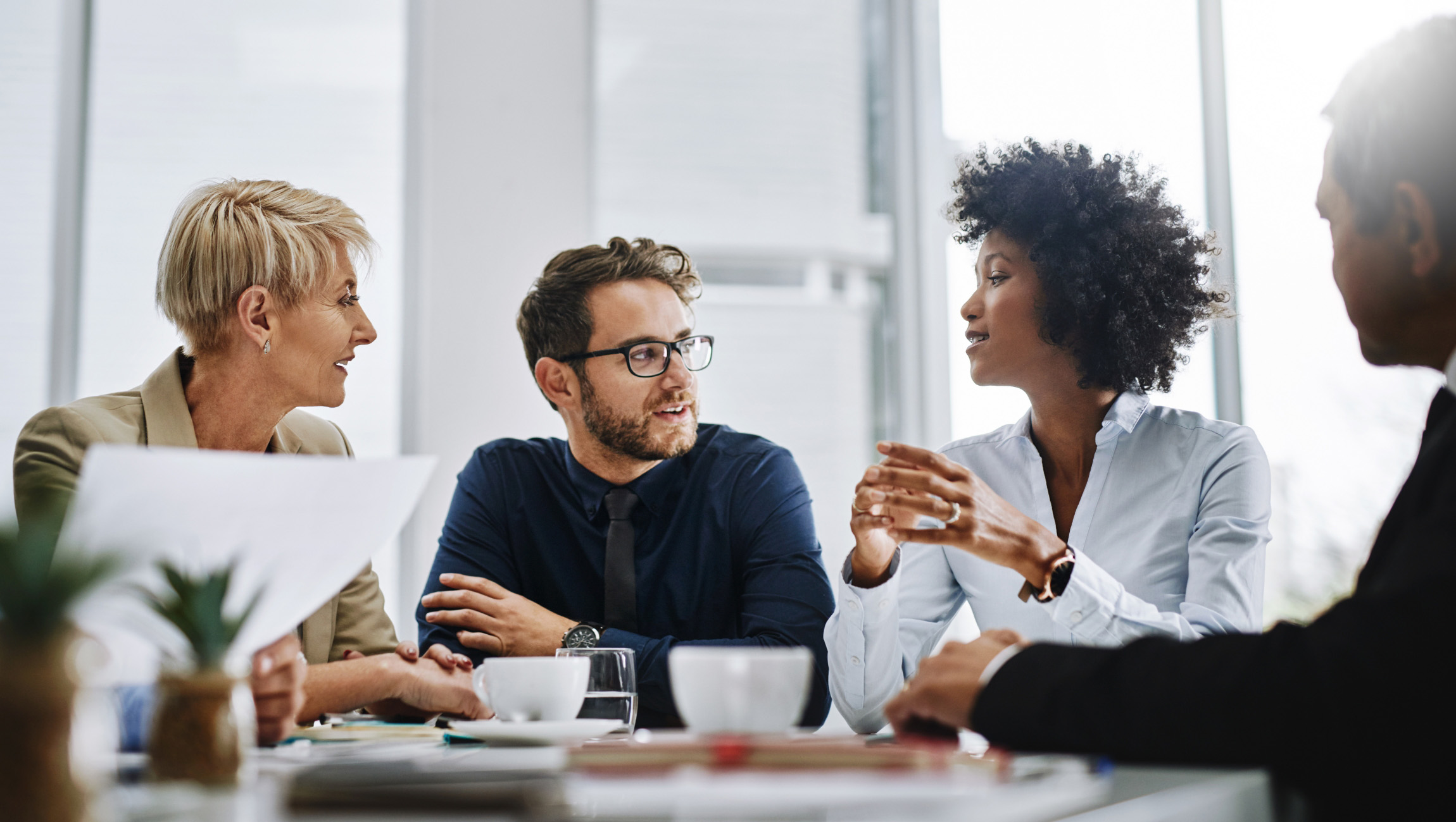 group of professional adults sitting at a table talking