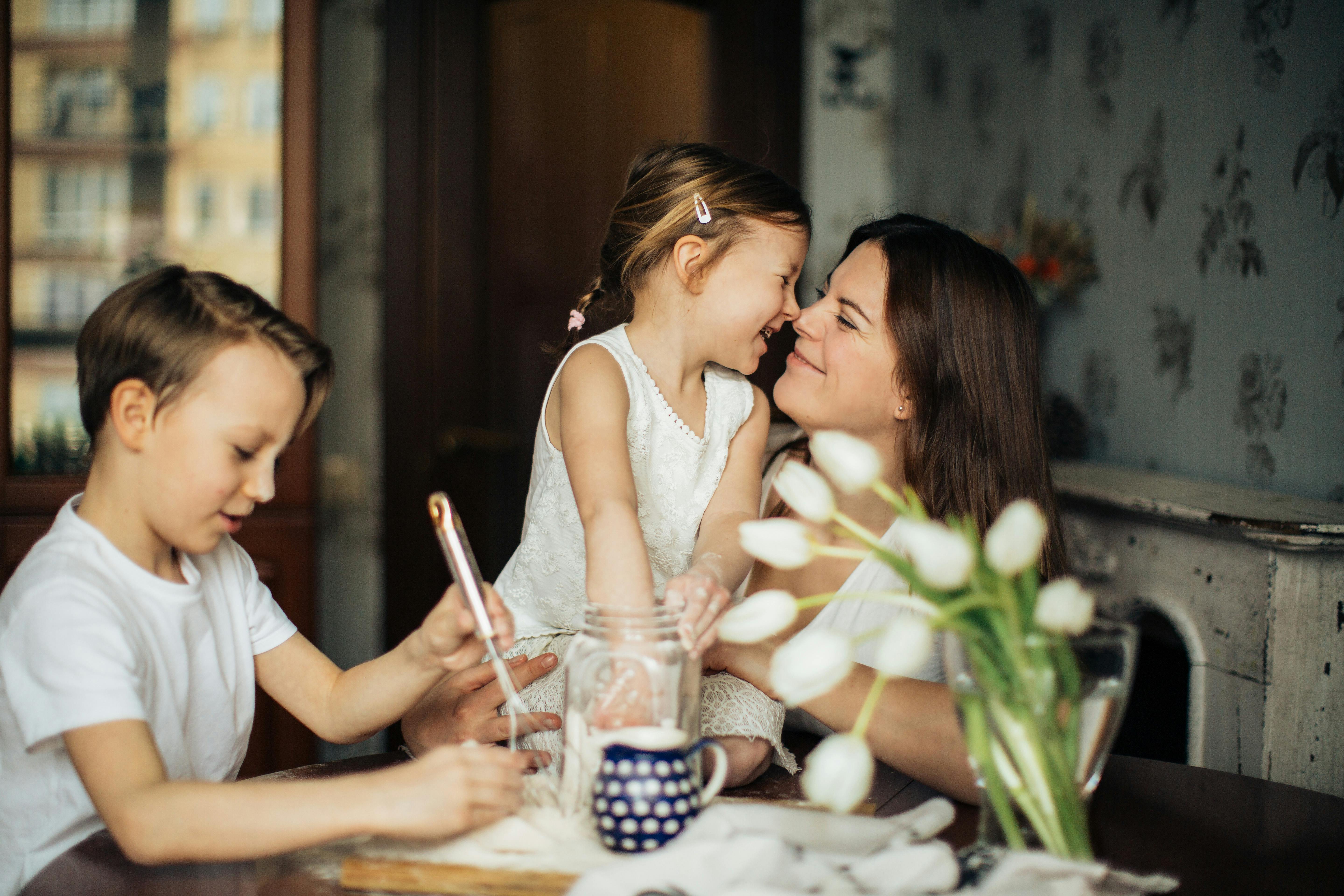 a woman and two children in the kitchen